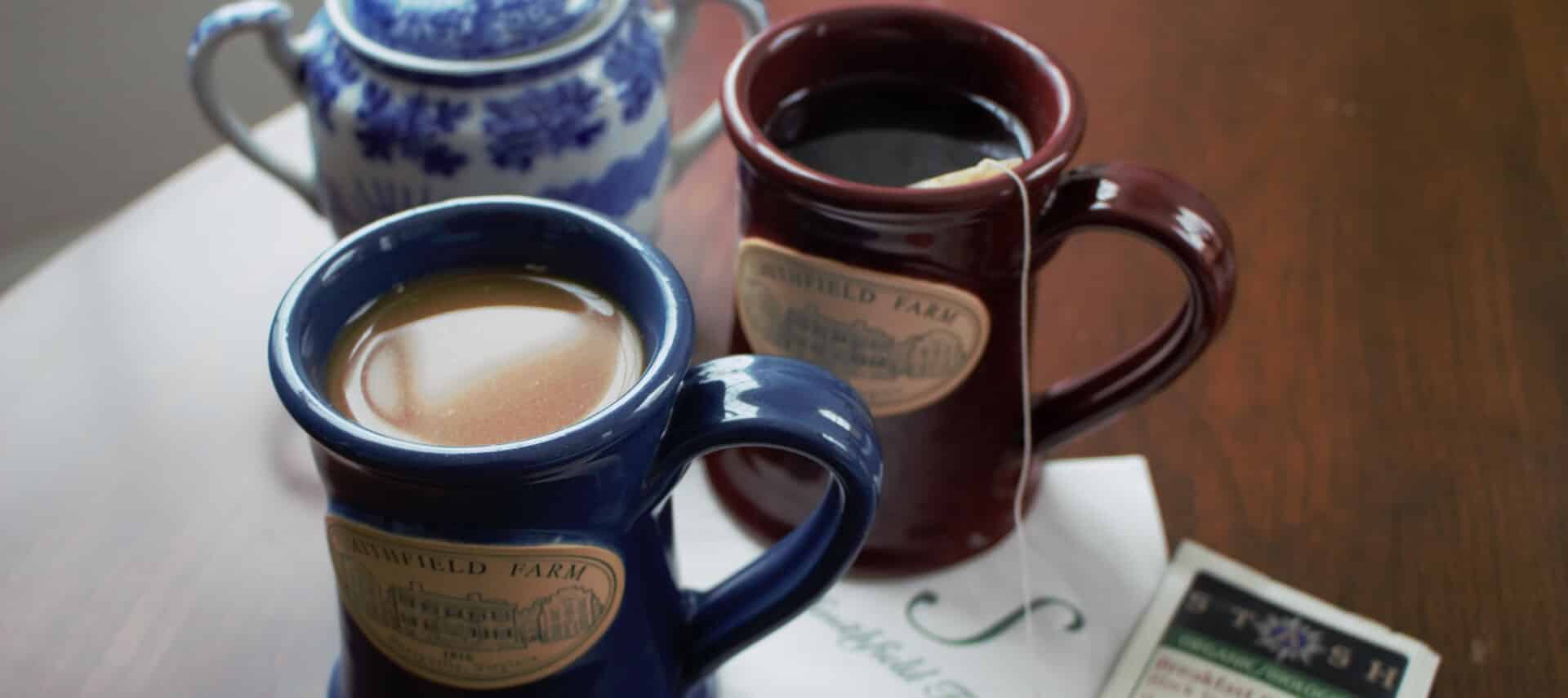 Two coffee mugs with the Smithfield Farm Bed and Breakfast logo on them